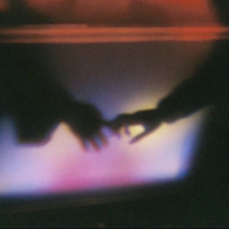 Two hands reaching toward each other in the evening light